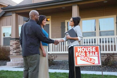 real estate agent congratulates buyers - how to sell as house as a real estate agent