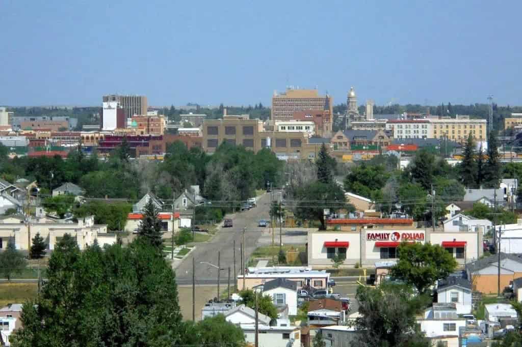 WY: Aerial view of Henderson, Nevada, with suburban houses, a highway, and mountains in the background.